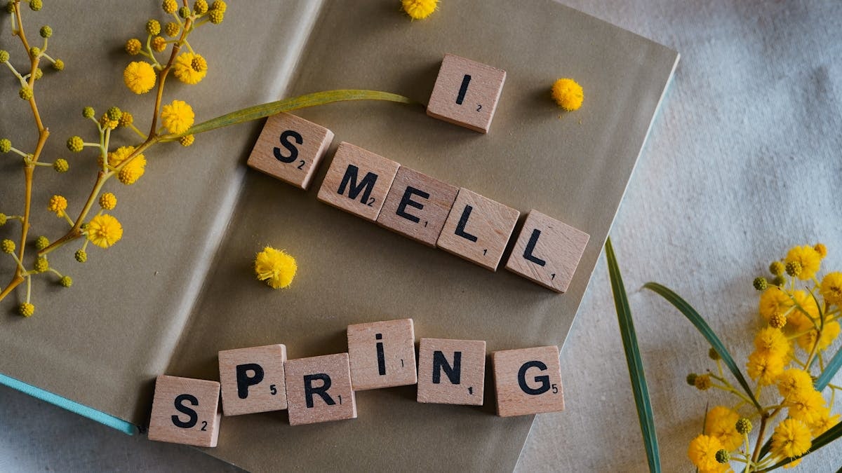 A beautiful spring-themed composition with yellow flowers and scrabble tiles spelling 'I smell spring'.